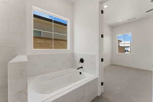 Bathroom featuring a garden tub and recessed lighting