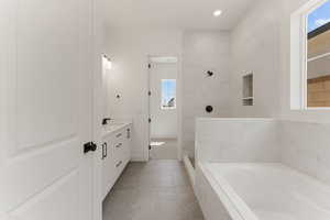 Full bath with vanity, a garden tub, and a walk in shower