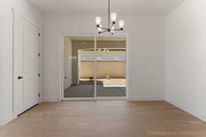 Unfurnished dining area with light wood finished floors and a chandelier