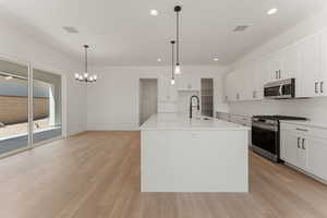Kitchen featuring stainless steel appliances, light wood finished floors, recessed lighting, and light countertops