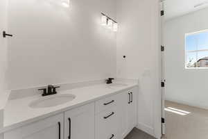 Bathroom with baseboards and double vanity
