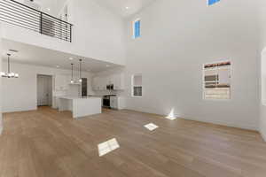 Unfurnished living room featuring light wood-type flooring, healthy amount of natural light, and recessed lighting