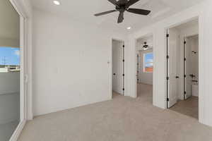 Unfurnished bedroom with light carpet, recessed lighting, ceiling fan, and attic access