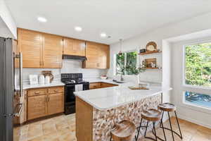 Kitchen with custom milled cabinets, spice rack and silestone counters.