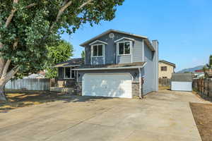 View of front of house with a chimney, driveway, and an attached garage
