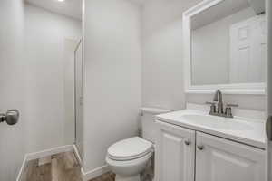 Bathroom with a stall shower, wood finished floors, and vanity