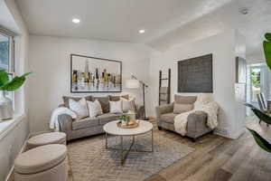 Living area featuring lofted ceiling, wood finished floors, and recessed lighting