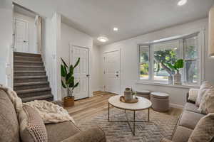 Living room featuring stairway, wood finished floors, and recessed lighting