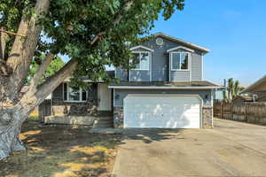 View of front facade featuring an attached garage, brick siding, and concrete driveway