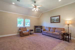 Living area with ornamental molding, lofted ceiling, ceiling fan, recessed lighting, and light tile patterned floors