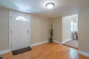 Entryway featuring plenty of natural light, light wood-style floors, and a textured ceiling