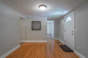 Foyer entrance featuring a textured ceiling and light wood-type flooring