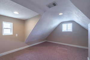 Bonus room featuring a textured ceiling, carpet, and recessed lighting