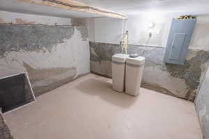 Unfinished below grade area featuring electric panel and a water softener
