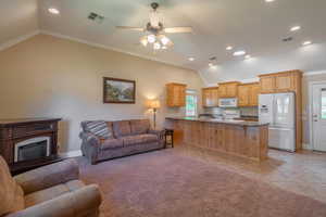 Living room featuring ornamental molding, vaulted ceiling, recessed lighting, light tile patterned floors, and ceiling fan
