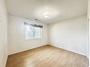 Spare room featuring a textured ceiling and light wood-style flooring