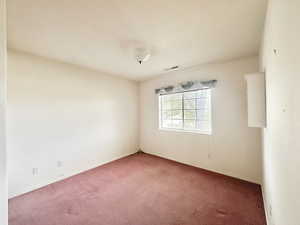 Carpeted spare room with baseboards and a textured ceiling
