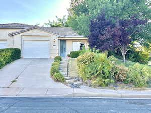 Ranch-style house with stucco siding, driveway, a garage, and a tile roof