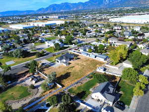 Aerial view of property and surrounding area featuring a mountain backdrop and nearby suburban area