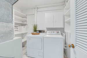 Laundry room featuring washing machine and clothes dryer and light tile patterned flooring