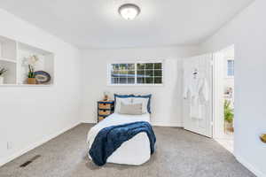 Carpeted bedroom featuring baseboards