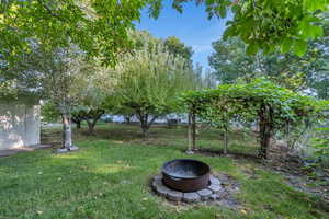 View of grassy yard featuring a fire pit