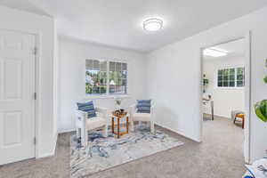 Living area with carpet flooring and plenty of natural light