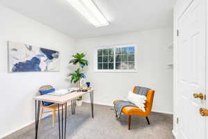 Carpeted office space with baseboards