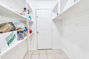 Walk in closet with light tile patterned floors