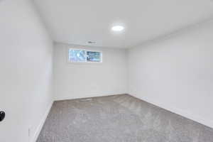 Carpeted spare room with baseboards