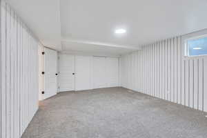 Below grade area with wooden walls and carpet floors
