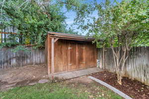View of shed with a fenced backyard