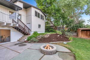 View of side of home featuring stairs, an outdoor fire pit, and a patio
