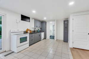 Kitchen with gray cabinets, white appliances, dark countertops, recessed lighting, and light tile patterned flooring