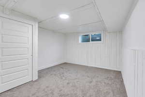 Finished below grade area with wooden walls and carpet floors