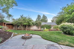 Fenced backyard featuring a patio and an outdoor fire pit