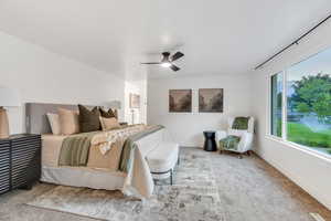 Carpeted bedroom featuring baseboards and ceiling fan