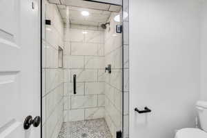 Bathroom featuring toilet and a stall shower