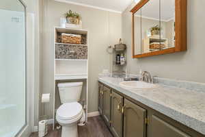 Full bath featuring vanity, wood finished floors, ornamental molding, a textured ceiling, and an enclosed shower