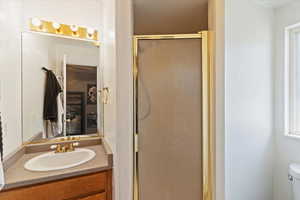 Full bath featuring a shower stall and vanity