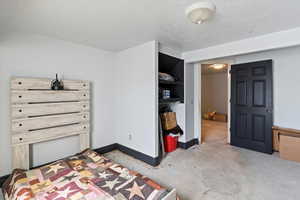 Bedroom with unfinished concrete floors and a textured ceiling
