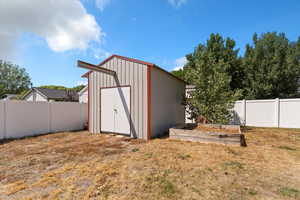 View of shed with a fenced backyard and a garden