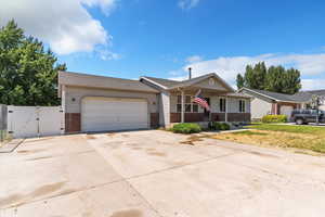 Ranch-style home featuring a gate, driveway, a garage, covered porch, and brick siding