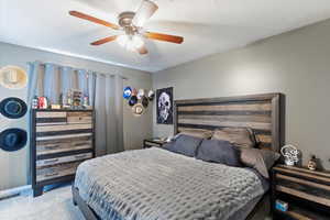 Bedroom featuring carpet, a textured ceiling, and ceiling fan