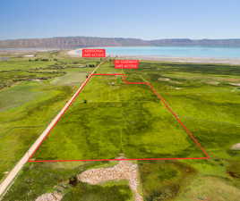 Aerial view of property and surrounding area featuring property parcel outlined and a water and mountain view