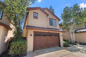 View of front of property with an attached garage, stucco siding, and driveway