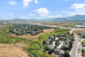 Aerial view of property's location featuring a water and mountain view and nearby suburban area