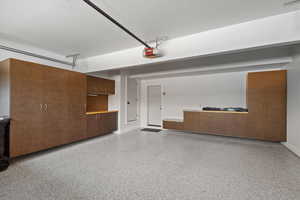 Garage with baseboards and a garage door opener