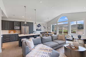 Living room featuring vaulted ceiling, recessed lighting, and light wood-style flooring