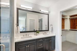 Full bathroom with double vanity and a shower stall